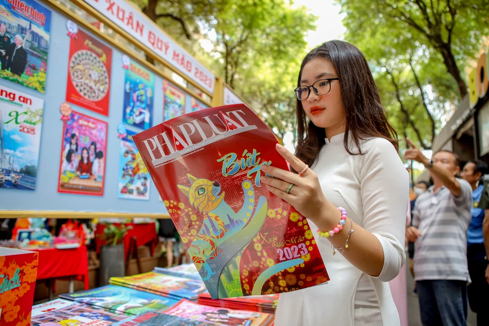 Bạn đọc xem giai phẩm báo Xuân Qúy Mão 2023 của Báo Pháp Luật TP.HCM. Ảnh: NGUYỆT NHI