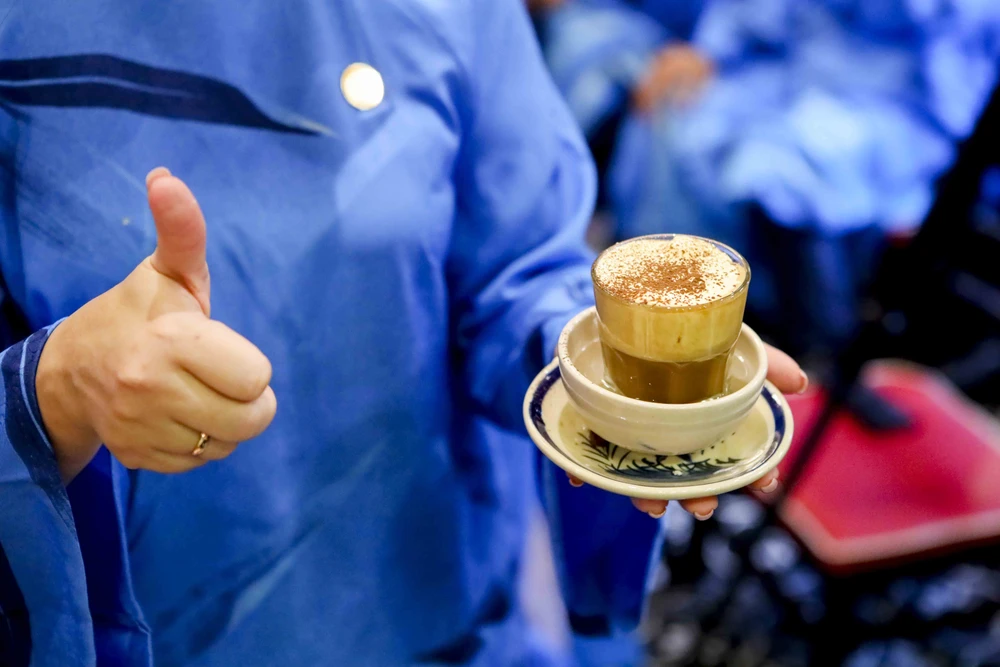 Đại biểu quốc tế mặc dài thưởng thức cà phê trứng