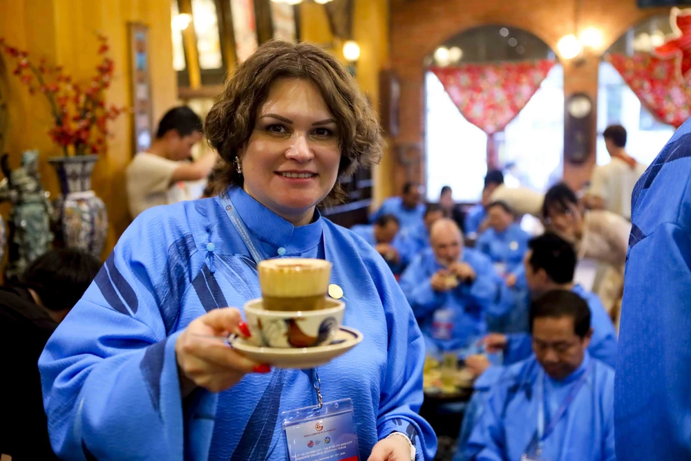 Đại biểu quốc tế mặc dài thưởng thức cà phê trứng