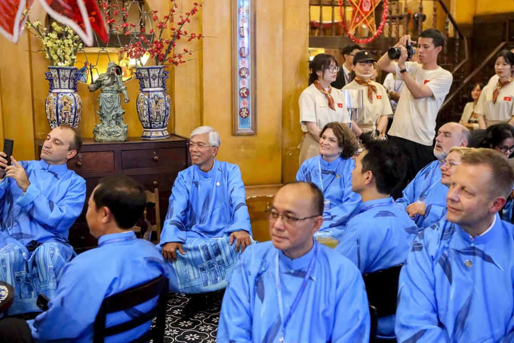 Đại biểu quốc tế mặc dài thưởng thức cà phê trứng