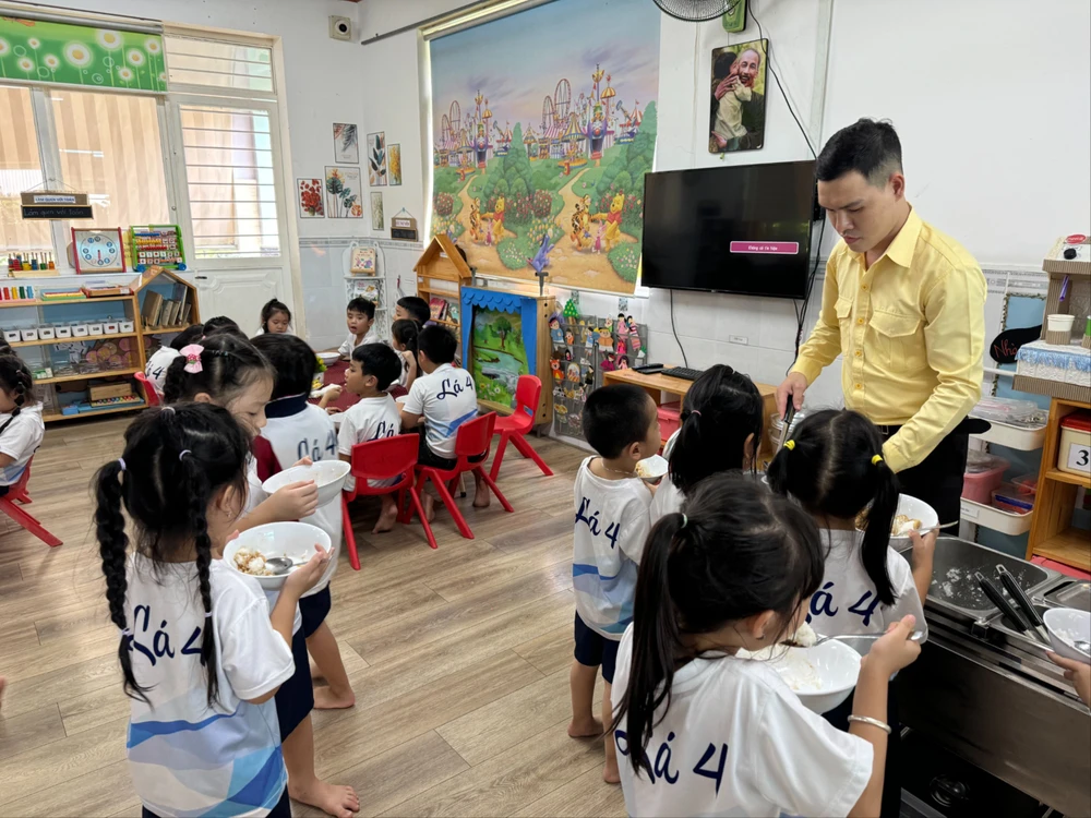 Thầy Lê Công Sự, giáo viên mầm non trường Mầm non Hoa Đào (Quận 12) sinh hoạt cùng các em nhỏ. Ảnh: KHÁNH QUỲNH