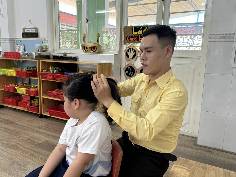 Thầy Lê Công Sự, giáo viên mầm non trường Mầm non Hoa Đào (Quận 12) sinh hoạt cùng các em nhỏ. Ảnh: KHÁNH QUỲNH