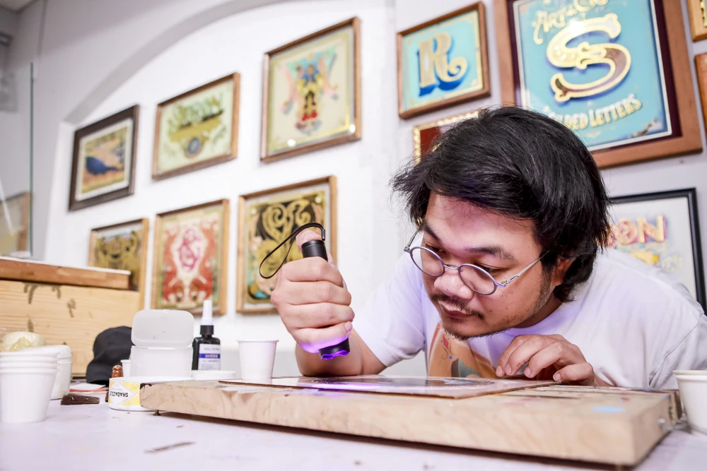 Chàng trai làm biển hiệu kính ngược dát vàng hiếm có ở TP.HCM