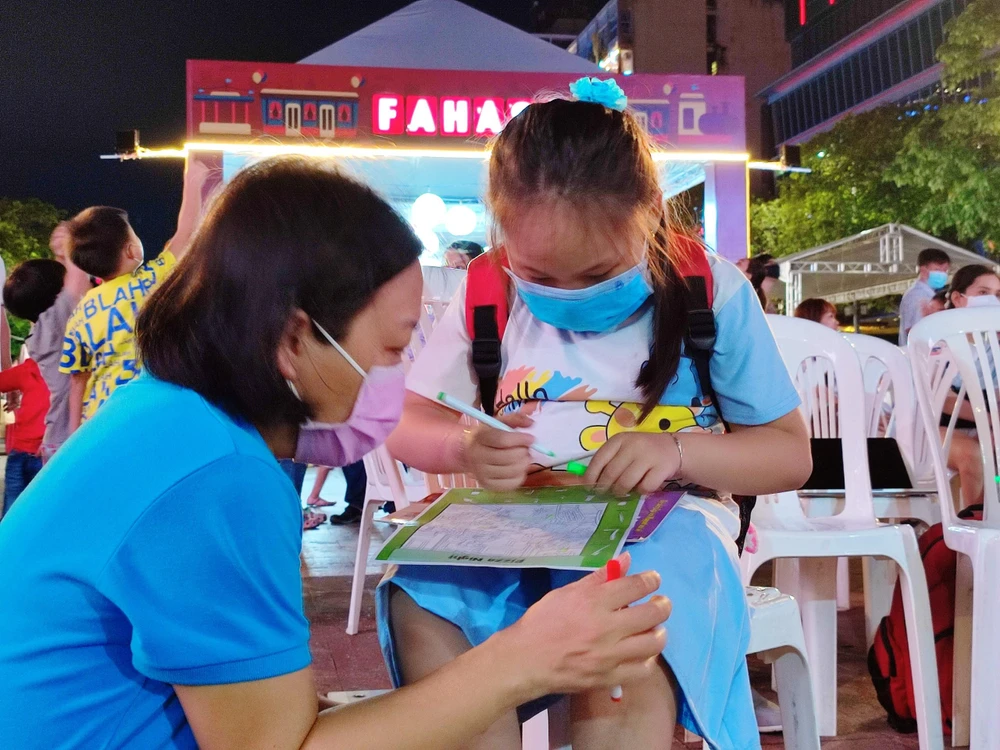 Các em bé theo ba mẹ đến phố đi bộ Nguyễn Huệ dự Ngày sách và Văn hoá đọc Việt Nam. Ảnh: NGUYỄN TRÀ