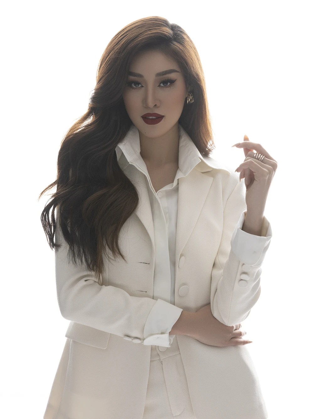 Trong tone trang phục vest trắng, Hoa hậu Khánh Vân chọn son môi đỏ đậm và tóc xoăn sóng, gợi đến hình ảnh nữ doanh nhân hiện đại, tự tin, như câu slogan mà cô từng chia sẻ trước đó: “Tự tin với lựa chọn của chính mình”.