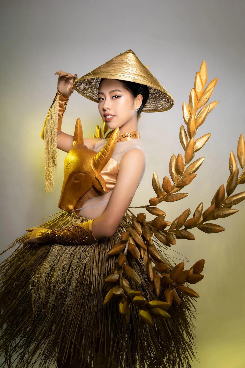 Độc đáo trang phục dân tộc nặng 7kg cùng Ngô Ngọc Gia Hân thi Hoa hậu Quốc tế. Trang phục lấy cảm hứng từ nền nông nghiệp lúa nước từ những hình ảnh gần gũi với làng quê Việt Nam như con trâu, nón lá, lúa rơm...