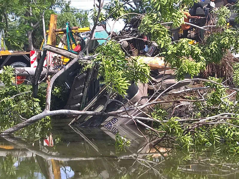Tài xế và phụ xe may mắn thoát ra ngoài kịp thời trước khi cabin chìm hẳn xuống nước.