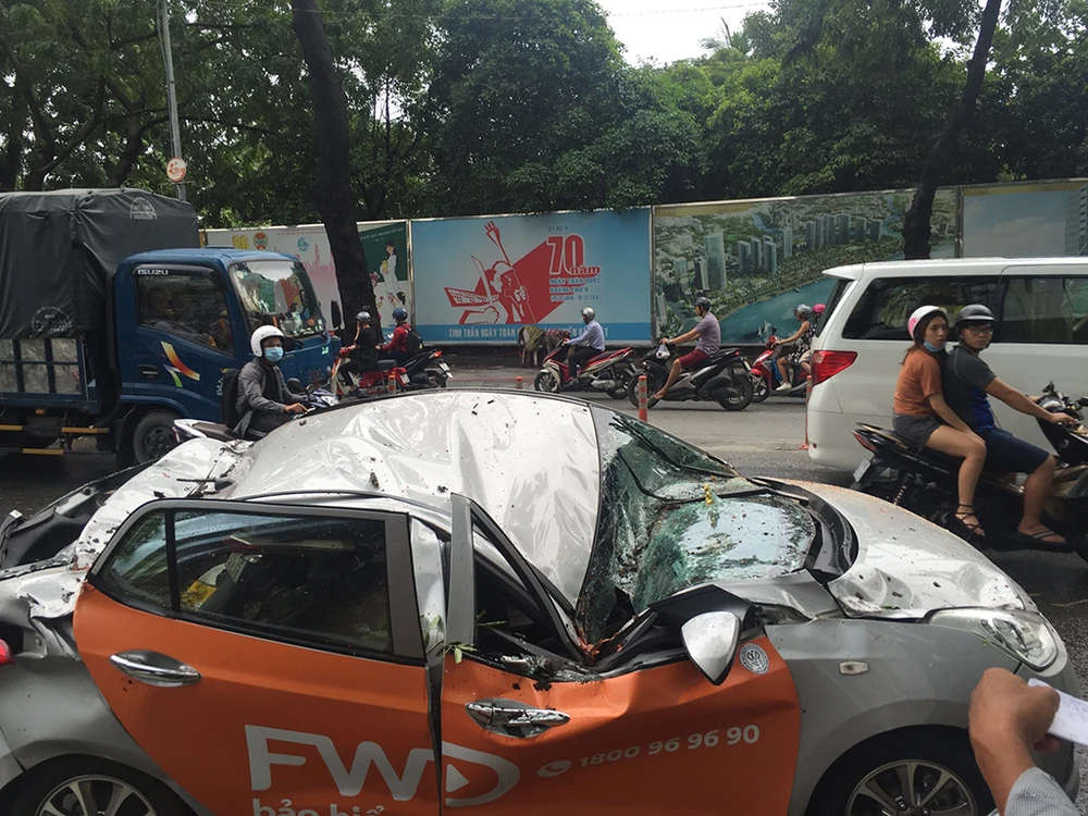 Chiếc xe taxi bị hư hỏng nặng, nữ hành khách trên xe bị thương được đưa đi cấp cứu. 