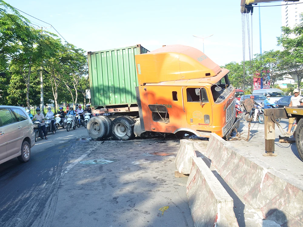 Chiếc container đang lưu thông trên xa lộ Hà Nội thì lao qua làn xe máy, tông văng nhiều mét dải phân cách. 