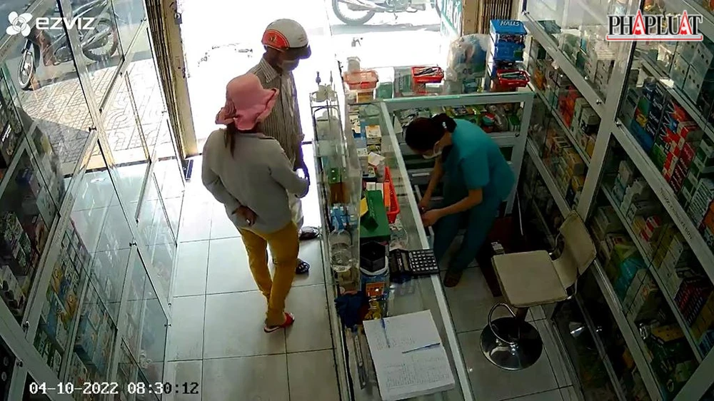 Người phụ nữ đưa hộp thuốc cho người đàn ông giấu vào quần. Ảnh chụp từ clip