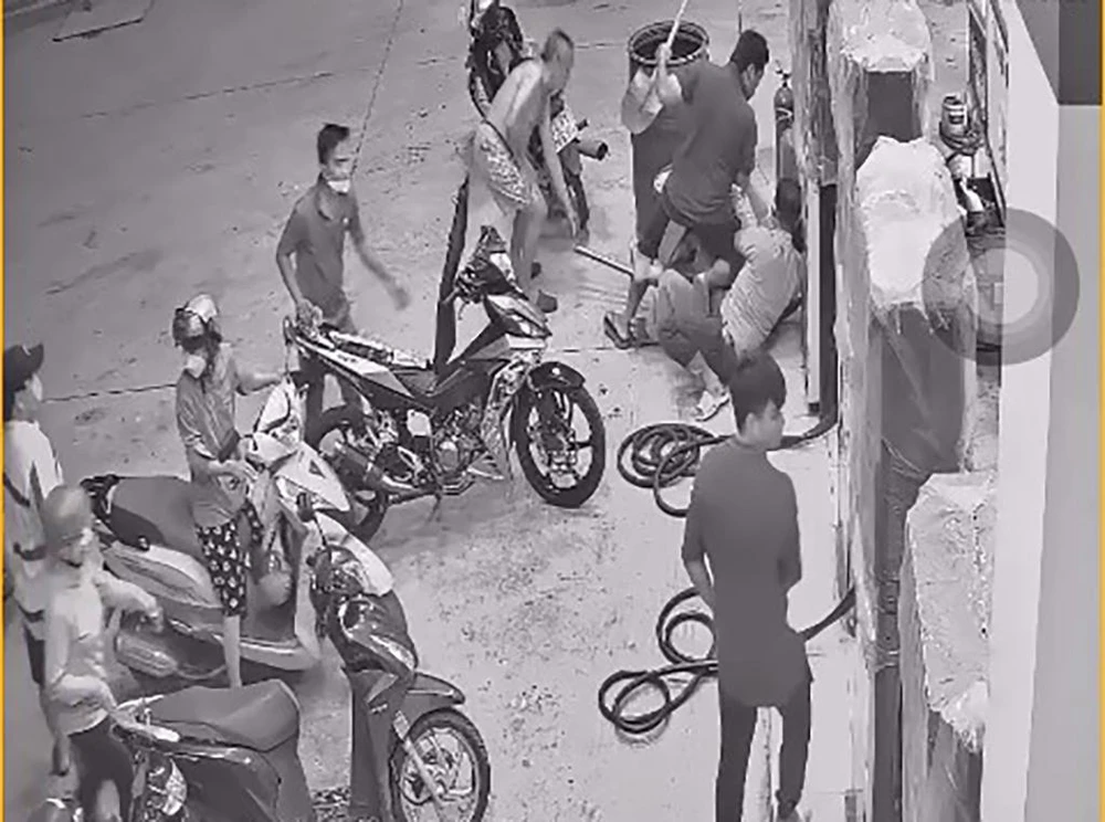 Trước đó, Hạnh vào cây xăng đổ xăng, hút thuốc, bị nhắc nhở và xô xát với hai nhân viên cây xăng. Ảnh chụp từ clip