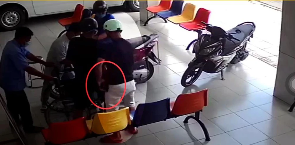 Người này nhét chiếc ví của ông T vào túi quần. Ảnh chụp từ clip Người này nhét chiếc ví của ông T vào túi quần. Ảnh chụp từ clip