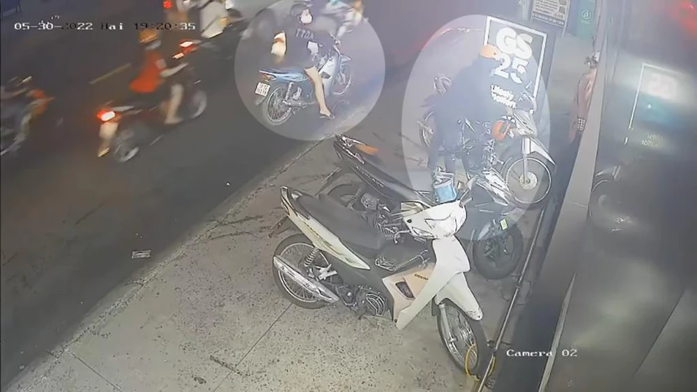 Nam thanh niên tiếp cận chiếc xe máy rồi bẻ khóa, ăn trộm. Ảnh chụp từ clip