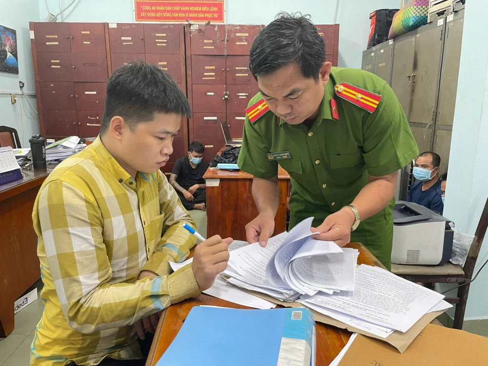 Vương (bên trái) tại cơ quan điều tra. Ảnh: HT