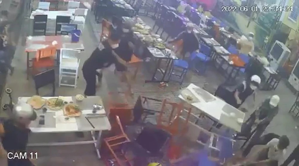 Trong quá trình này, một người trong nhóm truy sát đã trộm điện thoại của nạn nhân để trên bàn. Ảnh: Chụp từ clip