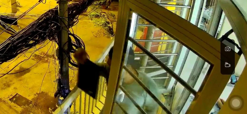 Người này lấy đi chiếc máy tính xách tay ra ngoài. Ảnh chụp từ clip