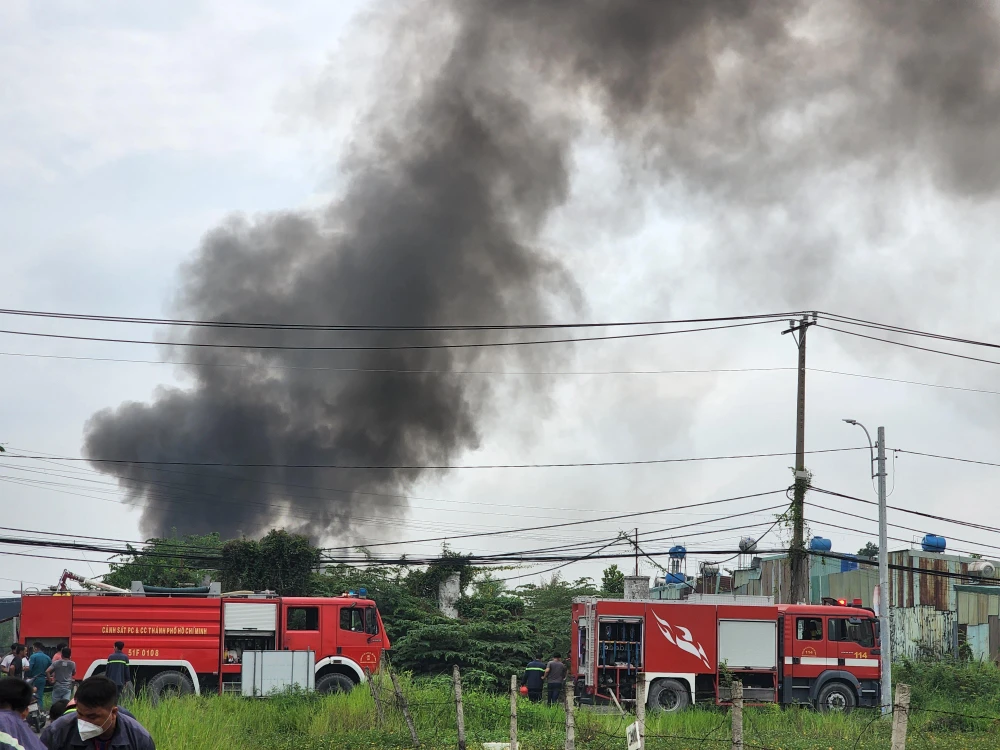 Cảnh sát PCCC Công an huyện Bình Chánh điều động nhiều phương tiện cùng hàng chục cán bộ chiến sĩ đến hiện trường khống chế đám cháy. Ảnh: HT