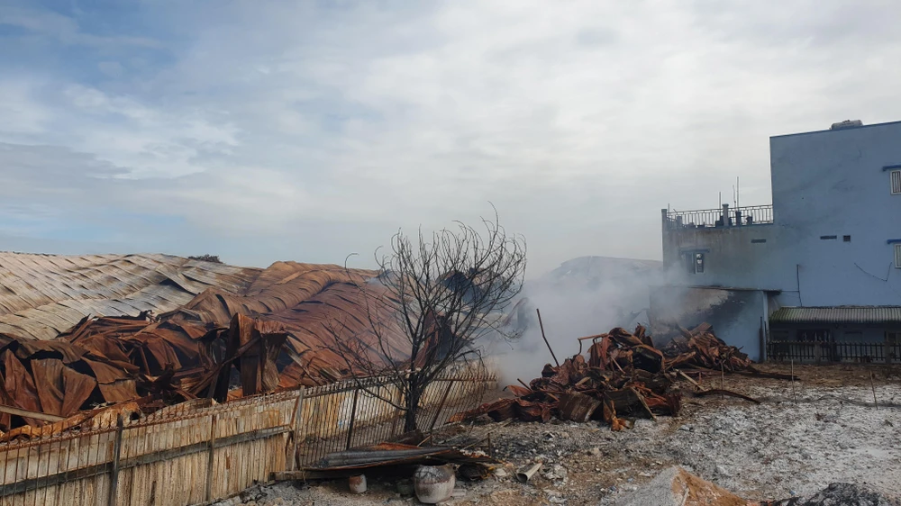 Đến sáng ngày 14-7, khói vẫn bốc lên từ nhà xưởng này. Ảnh: NT