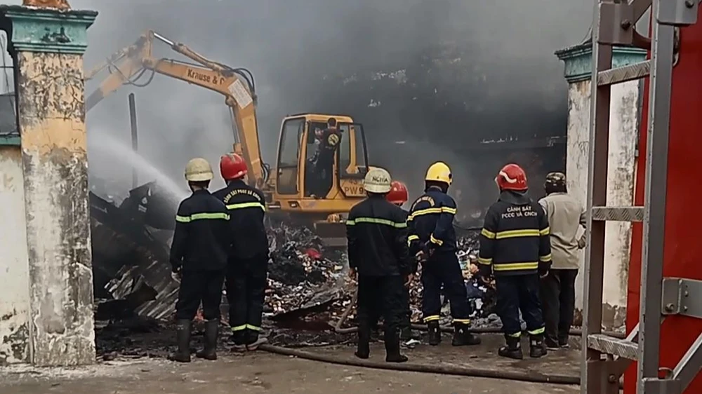 Cảnh sát PCCC huy động xe cuốc để khống chế đám cháy. Ảnh: NT