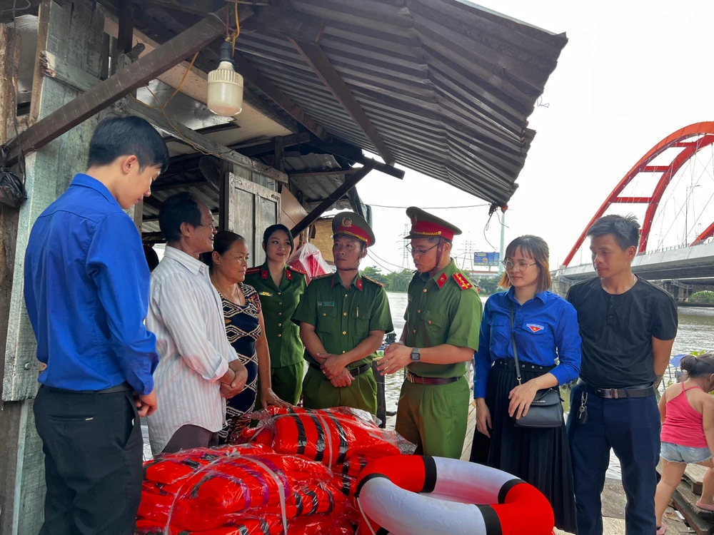 Đoàn công tác tặng 30 áo phao và phao tròn cứu sinh cho gia đình ông Ba Chúc. Ảnh: ĐN