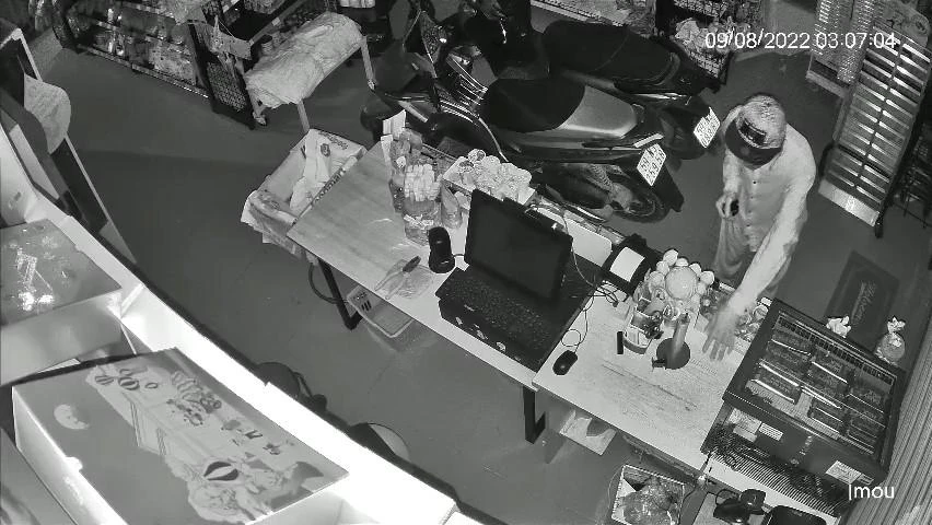 Người này thản nhiên đi lại, lục tìm tài sản. Ảnh chụp từ clip