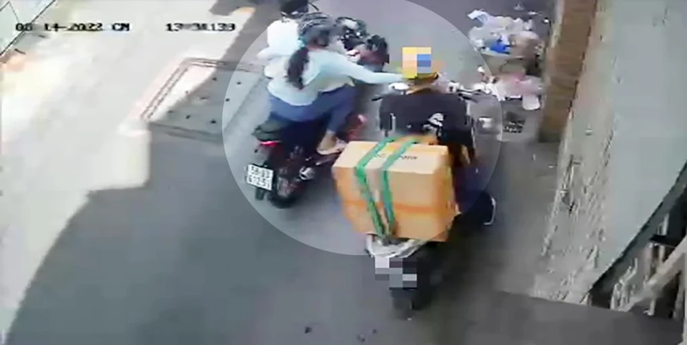 Đôi nam nữ tiếp cận, cướp giật chiếc iPhone của chị N cầm trên tay. Ảnh chụp từ clip