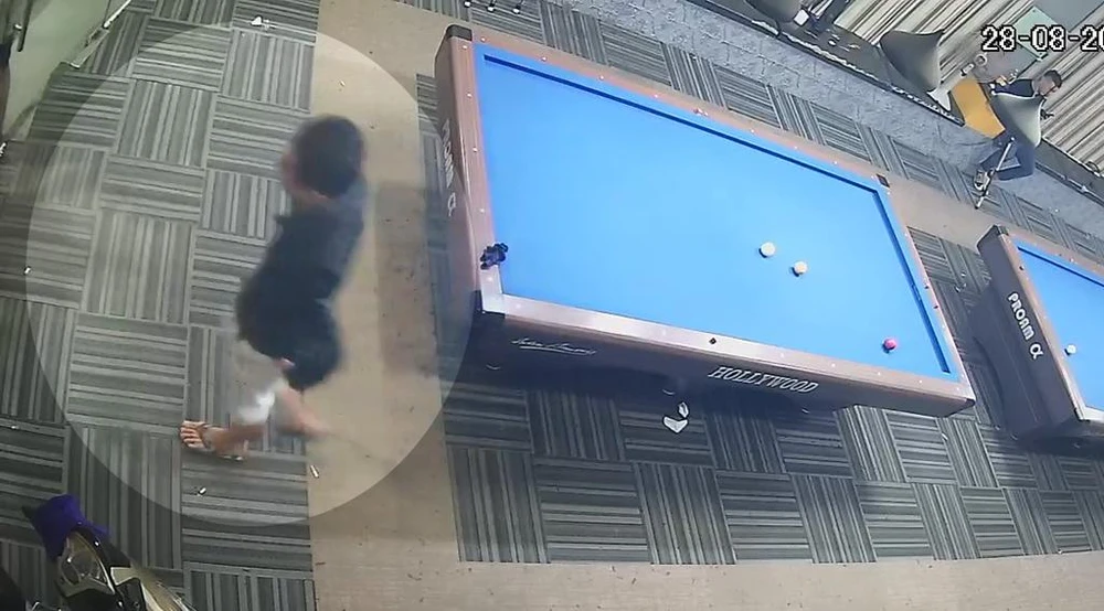 Nam thanh niên bỏ chiếc điện thoại vào túi quần rồi rời đi. Ảnh chụp từ clip