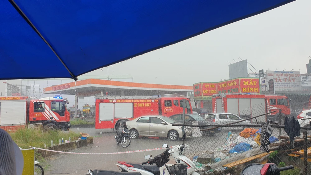Sáng 7-9, trời đổ mưa lớn trong lúc cảnh sát PCCC Công an tỉnh Bình Dương đang tiếp cận hiện trường, hút khói ra ngoài. Ảnh: TÂN THƠ