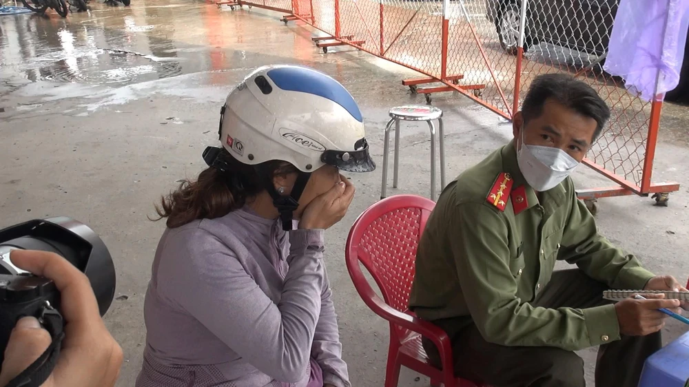 Người phụ nữ khóc, trình báo thông tin với công an tại hiện trường. Ảnh: TÂN THƠ