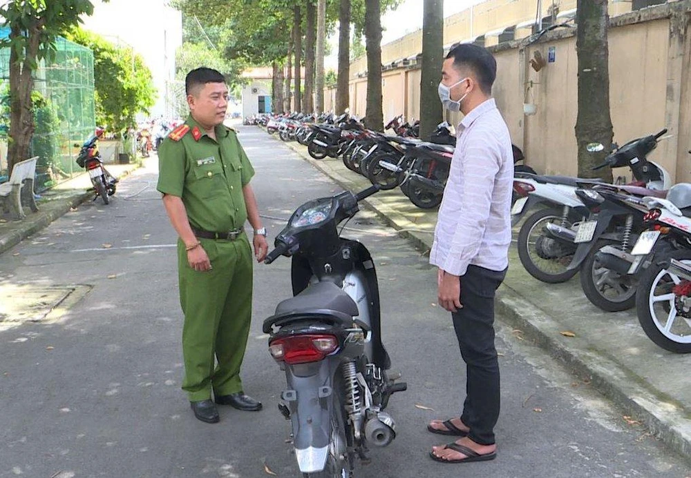 Công an trao trả chiếc xe trong vụ cướp cho tài xế xe ôm. Ảnh: CA