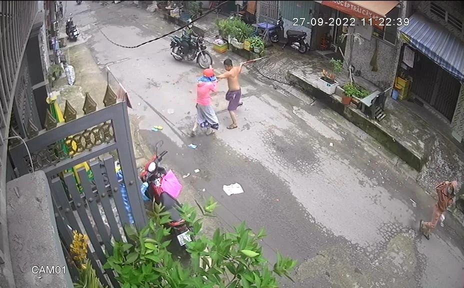 Người đàn ông tiếp tục đánh chị T thêm một gậy. Ảnh chụp từ clip