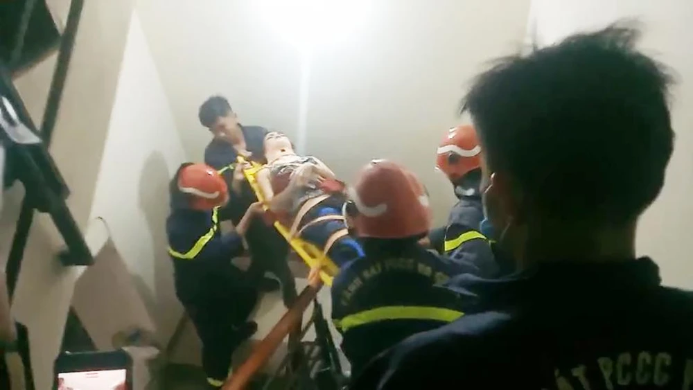 Người phụ nữ được lực lượng cảnh sát PCCC và CNCH đưa xuống bằng đường thang bộ. Ảnh: PC07