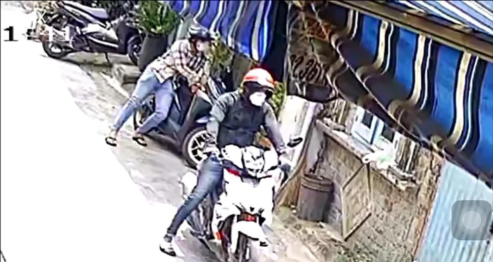Hai nam thanh niên phối hợp bẻ khóa, trộm xe máy của anh D. Ảnh chụp từ clip