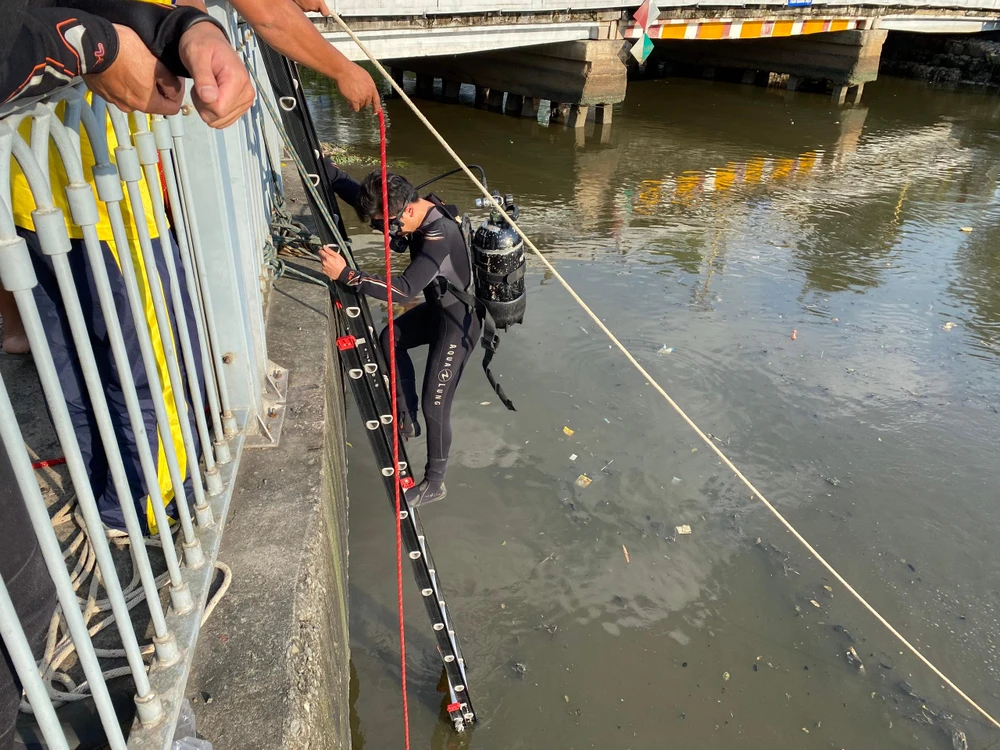 Người nhái mang đồ chuyên dụng lặn tìm dưới kênh Nhiêu Lộc - Thị Nghè. Ảnh: CA