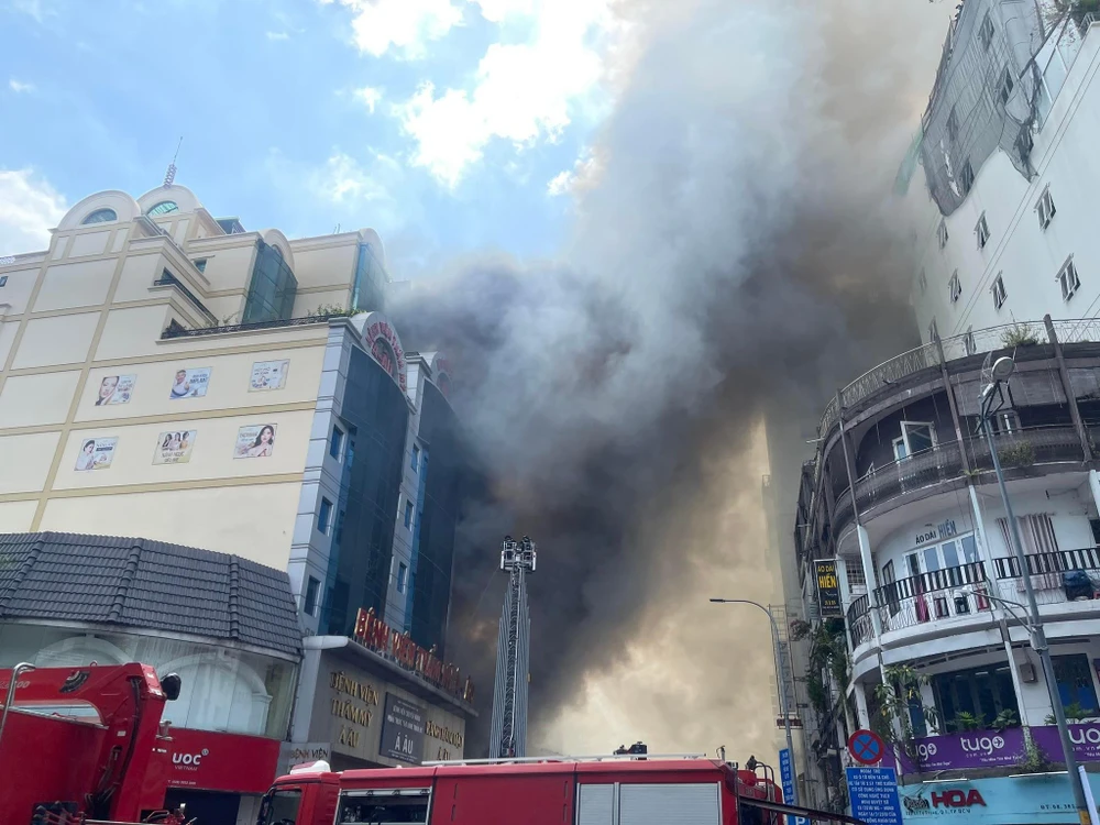 Cảnh sát huy động xe thang tiếp cận từ phía trên để khống chế khói lửa. Ảnh: HT