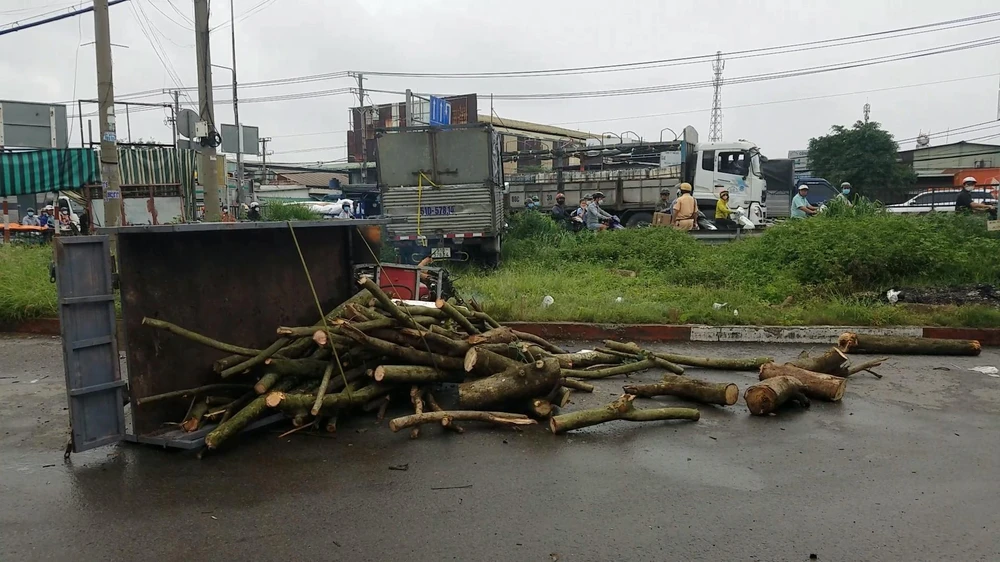 Chiếc xe ba gác máy chở củi bị tông ngã ra đường. Ảnh: HT