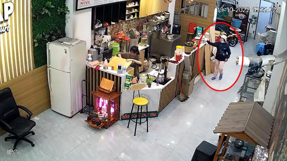 Người phụ nữ vào tiệm trà sữa hỏi mua ba ly nước nhưng thực chất là để dàn cảnh trộm điện thoại. Ảnh chụp từ clip