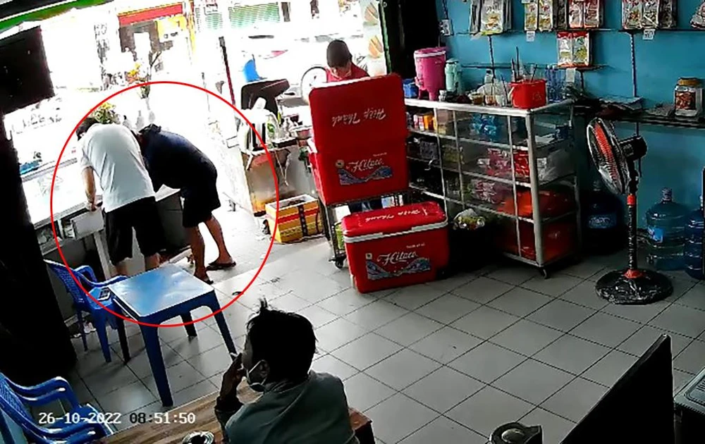 Người này sau đó tiến lại gần anh T, rồi cho tay vào hộc tủ. Ảnh chụp từ clip