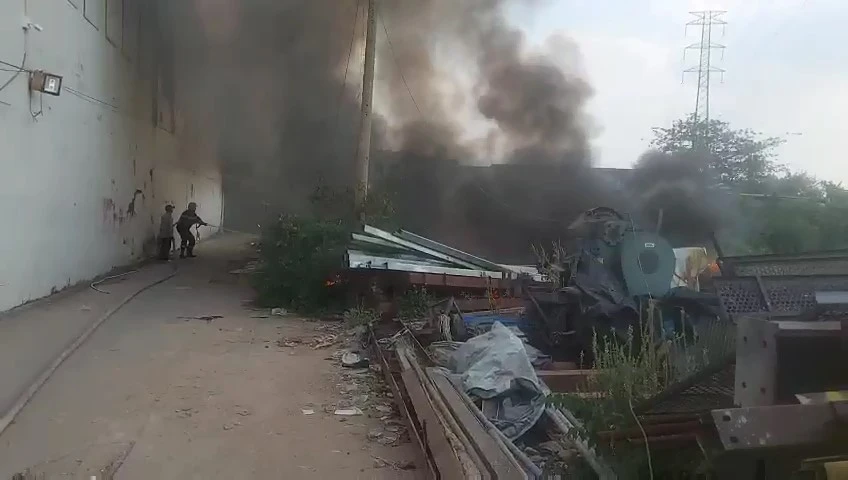 Khói lửa bùng lên từ bãi rác lan sang khu vực chứa phế liệu trong con hẻm. Ảnh: HT