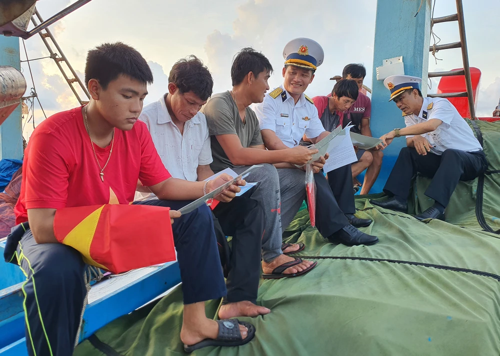 Thiếu tá Trần Cộng Hòa và đại úy Vũ Hoàng Tùng gặp gỡ các ngư dân neo đậu tại âu tàu trên đảo Trường Sa. Ảnh: NT