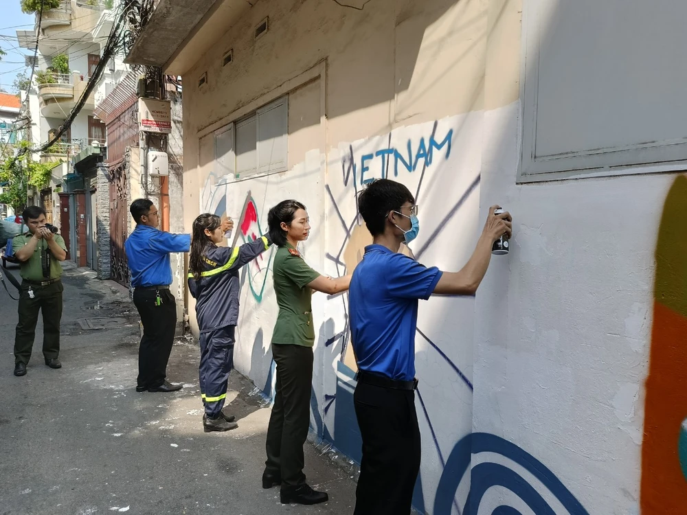 Công an phối hợp gỡ bỏ quảng cáo sai quy định ở khu vực công cộng và sơn, vẽ trang trí tạo cảnh quan đẹp mắt. Ảnh: HT