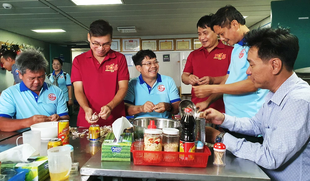 Các thành viên nam trong đoàn công tác cũng tham gia phụ nấu bếp với nụ cười luôn nở trên môi. Ảnh: NT