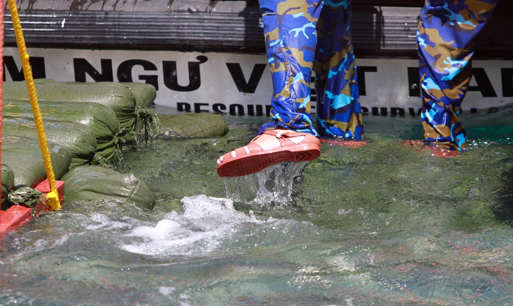 Suốt thời gian đón đưa các thành viên trong đoàn công tác, các cán bộ chiến sĩ đều đứng trong nước. Ảnh: NT