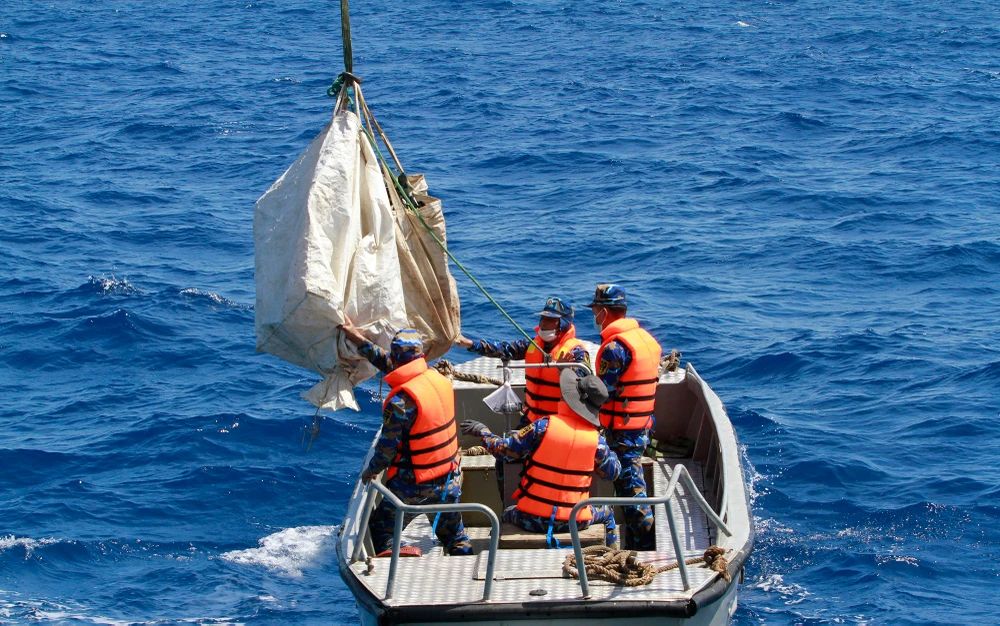 Hàng hóa sẽ được một cano khác đưa lên bằng cần cẩu cao hàng chục mét. Ảnh: NT