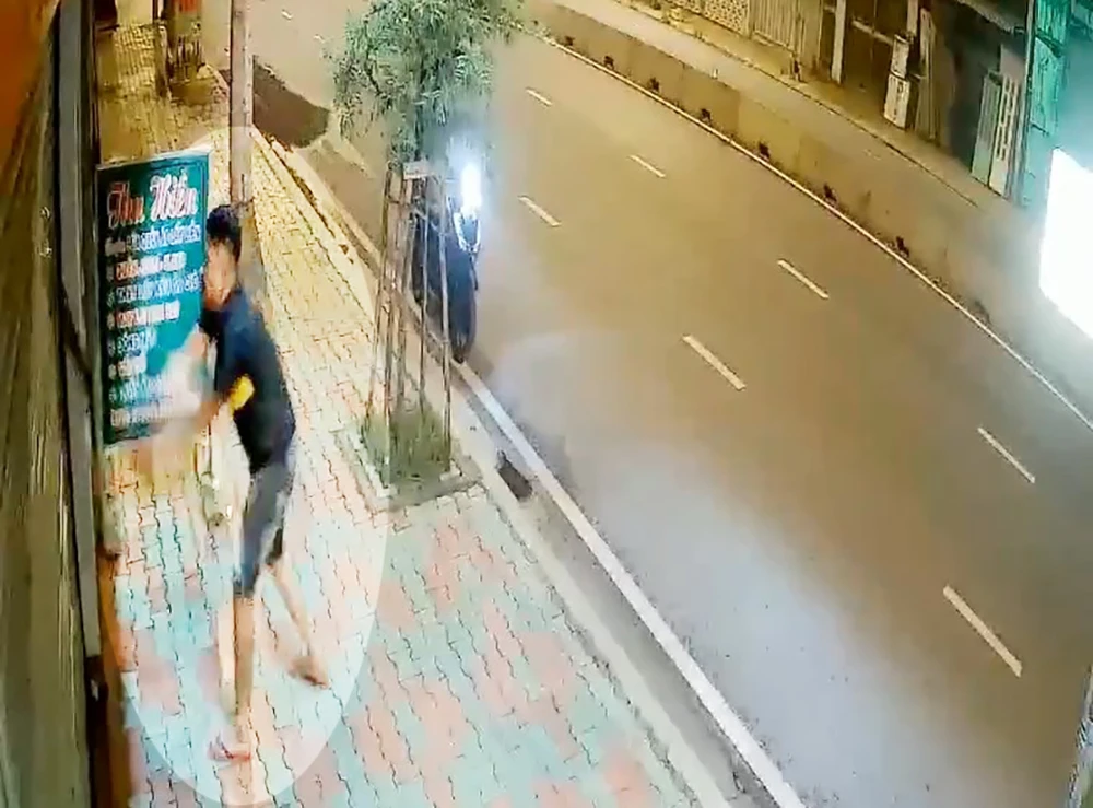 Người này chém liên tiếp vào cửa cuốn bằng sắt sau đó. Ảnh cắt từ clip