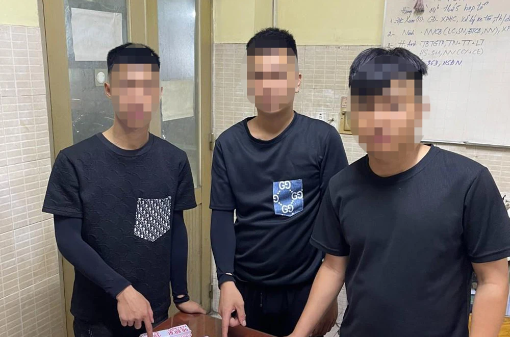 Công an quận Tân Phú phát hiện ba người đang dán quảng cáo sai quy định trên đường Trường Chinh nên mời làm việc. Ảnh: CA