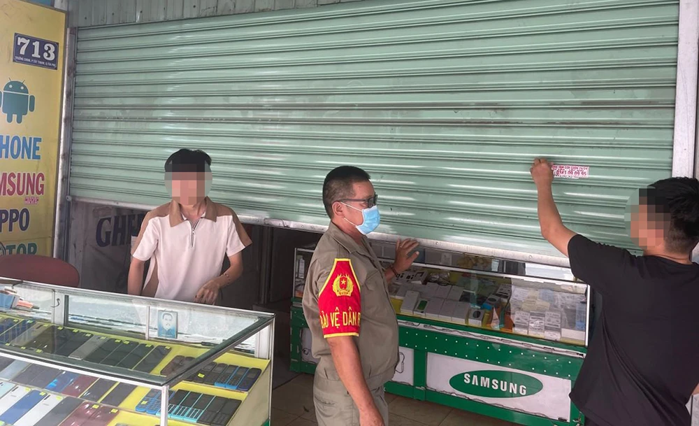 Công an đã bắt buộc ba thanh niên này tự tay bóc gỡ những quảng cáo đã dán trước đó. Ảnh: CA