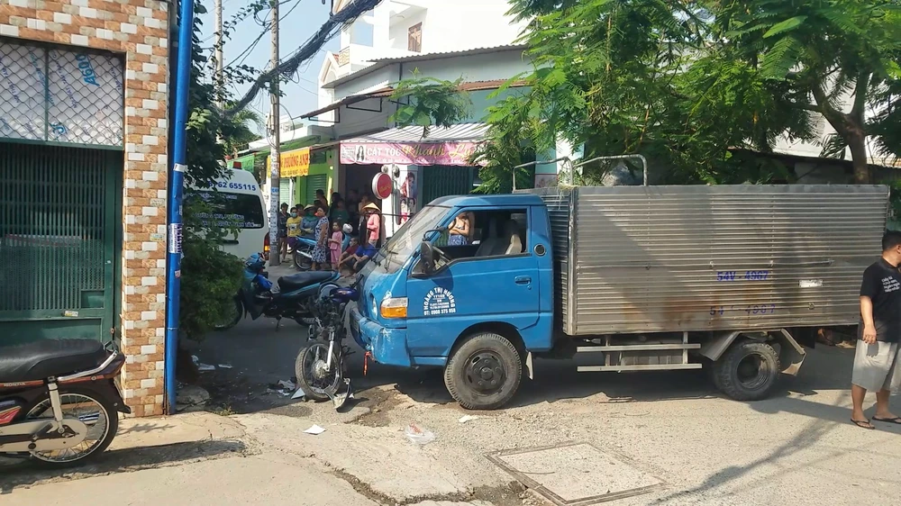 Sau va chạm, người phụ nữ và xe máy bị ô tô tải tông, đẩy vào tường nhà dân. Ảnh: HT