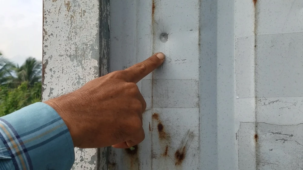 Một vết đạn bắn trúng tôn gây ra vết móp ở con hẻm. Ảnh: HT Một vết đạn bắn trúng tôn gây ra vết móp ở con hẻm. Ảnh: HT