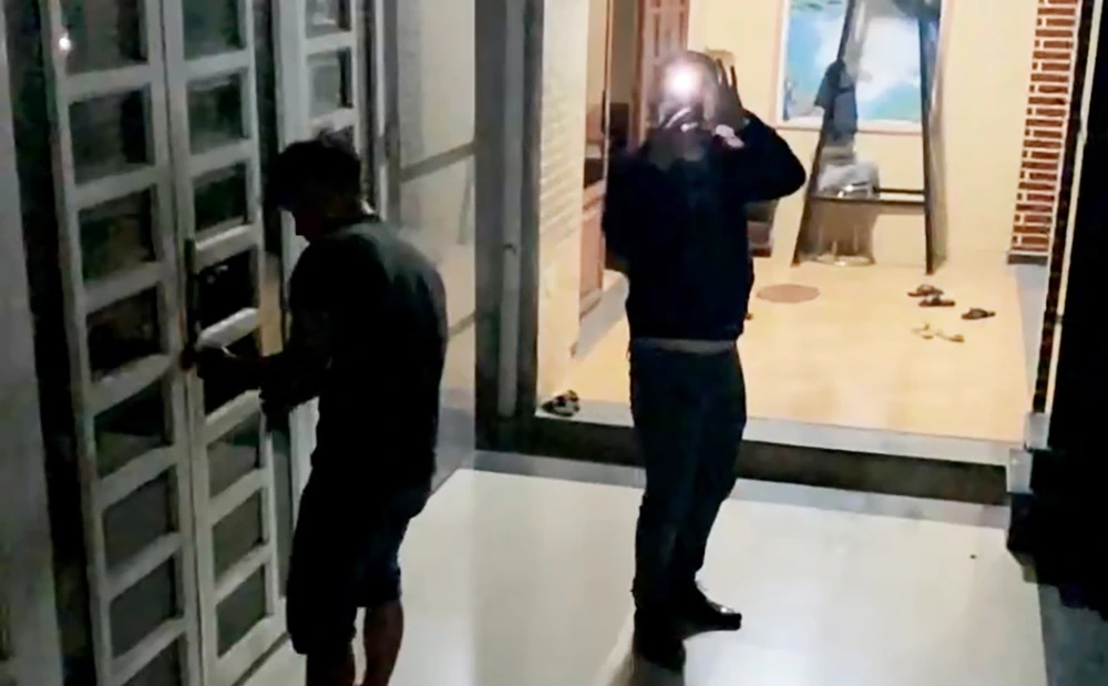 Những người lạ mặt tới phá khóa căn nhà trên địa bàn xã Phạm Văn Hai, huyện Bình Chánh. Ảnh cắt từ clip